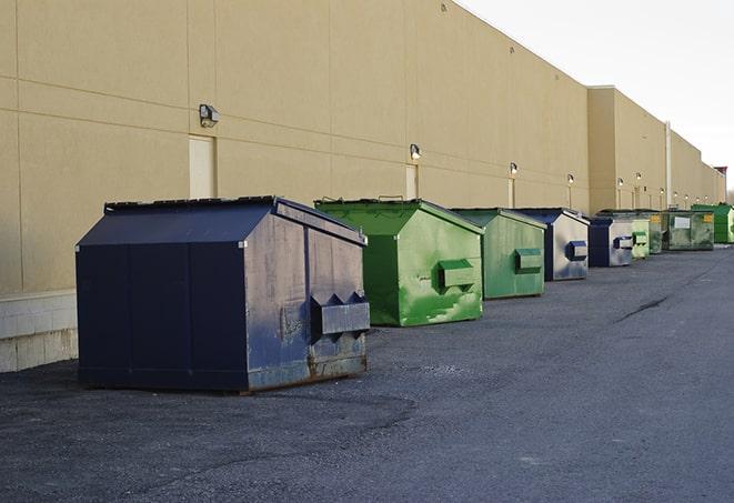 a construction worker moves construction materials near a dumpster in Dayton OH